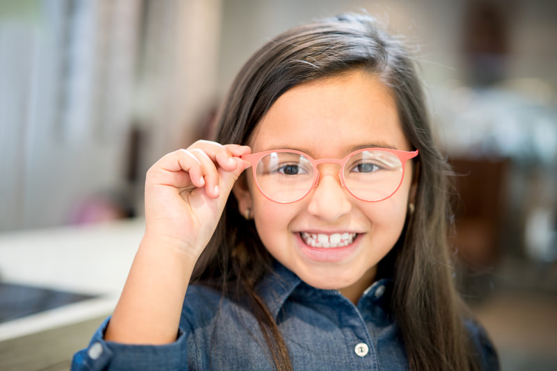 Child wearing glasses considering future laser eye surgery to reduce dependence on glasses